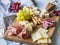 Cheese and meat wine snack set on wood board . Variety of cheese, salami, prosciutto, bread sticks, honey, grapes and two glasses