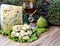 Cheese with mold on a green lettuce leaf with figs on a wooden background. Golden shot glass with alcohol