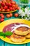 Cheese pancake with jam and fresh cherries. Wooden turquoise background. Top view. Close-up