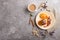 Cheese pancakes with caramel sauce on a beige ceramic plate and a cup of coffee on a gray concrete background. top view