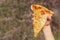 Cheese pizza. A child`s hand holds a piece of pizza