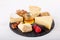 Cheese plate. Assortment of French cheese with nuts, grape, berries, dried fruits and honey on slate board on white. Camembert,