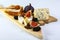 Cheese plate with blue cheese, brie, truffle hard cheese with grapes, figs, honey, dried fruits and nuts on white table. Top view