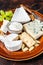 Cheese plate with Brie, Camembert, Roquefort, blue cream cheese, grape and nuts. Dark background. Top view
