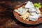 Cheese plate with Brie, Camembert, Roquefort, blue cream cheese, grape and nuts. Dark background. Top view. Copy space