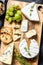 Cheese plate with Camembert, brie and blue cheese with grapes and walnuts. Black background. Top view
