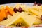 Cheese plate - Charcuterie Board with various types of hard cheese and String cheese., decorated with grapes close up