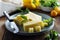 Cheese plate with delicous cheese slices and a cheese knife, wooden table