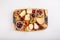 Cheese plate. French cheese with nuts, grape, berries, dried fruits and honey on cutting board on white. Camembert, Livarote, Pont