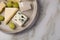 Cheese plate platter with selection Edamer, Parmesan, goat, blue and cream cheese, peer and grapes on marble background