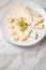 Cheese plate platter with selection Edamer, Parmesan, goat, blue and cream cheese, peer and grapes on marble background