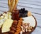 Cheese plates served with grissini, crackers, dates, jam, olives and nuts on wooden background. Cheese board. Snack to wine