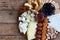 Cheese plates served with grissini, crackers, dates, jam, olives and nuts on wooden background. Cheese board. Snack to wine