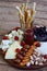 Cheese plates served with grissini, crackers, dates, jam, olives and nuts on wooden background. Cheese board. Snack to wine