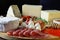 Cheese platte with different cheeses, meats on wooden board