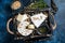 Cheese platter with brie and camembert, wooden tray with nuts. French Dairy products. Blue background. Top view