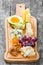 Cheese platter garnished with pear, honey, walnuts, grapes, carambola, physalis on cutting board