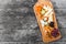 Cheese platter garnished with pear, honey, walnuts, grapes, carambola, physalis on cutting board on wooden background