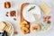 Cheese platter with a selection a cheeses, crackers, figs, nuts and honey, overhead table scene on a marble background