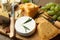 Cheese platter with specialized knife and fork on wooden table, closeup