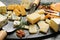 Cheese platter with specialized knives and fork on table, closeup view