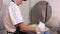 Cheese production - man in gloves working with a cheese making machine - removes excess liquid from the vat