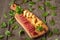 Cheese and salami on kitchen board on rustic background. Top view with copy space and herbs .