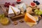 Cheese selection on wooden rustic background. Cheese platter with different cheeses, served with grapes, figs, nuts and honey