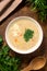 Cheese soup with corn and turkey meat. Sprinkled with chopped parsley. On a wooden table, a spoon on the bottom, a bunch of