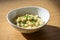 Cheese spaetzle or in austria kaesspatzn in white bowl with green chive bowl
