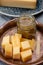 Cheese tasting, small pieces of old Dutch hard cheese and bowl with homemade dill-mustard sauce