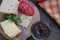 Cheese with tomatoes  and coffee lies on a board on a brown table.