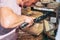 A cheese trader in the market cuts a large piece of cheese for the buyer