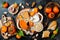 Cheese variety board or platter with cheese assortment, persimmons, honey and nuts. Black stone background.