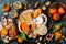 Cheese variety board or platter with cheese assortment, persimmons, honey and nuts. Black stone background.