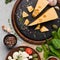 Cheese variety, olives and fresh herbs on concrete background.