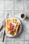 Cheese waffles with ham, cream cheese and cucumber with cutlery on gray tile background, space for text. Delisious