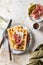 Cheese waffles with ham, cream cheese and cucumber with cutlery and linen napkin on beige textured background. Delisious