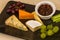 Cheeseboard platter with grapes and pickle