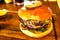Cheeseburger in brioche bun on wooden board in pub