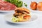 Cheeseburger, chicken cutlet, bacon, tomatoes and slices of cheese, dressed with sauce and green salad for a restaurant menu