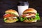 Cheeseburger and cup of coffee on a wooden background. Hamburger with cheese. Burger isolated. Tasty dinner