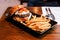 Cheeseburger with grilled beef, feta cheese and sliced tomato served with fries in black plate