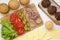 Cheeseburger ingredients on a white wooden background, top view. Flat lay, from above, overhead. Closeup