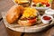 Cheeseburger with salad on a wooden tray.