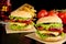 Cheeseburgers,french fries on wooden desk on black