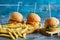 Cheeseburgers with fry potato on the wooden board