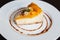 Cheesecake with caramel and peaches on a white plate