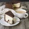 Cheesecake with chocolate and cup of coffee. Slice of classical New York cheesecake poured with chocolate sauce. Rustic