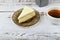Cheesecake with coffee on a light wooden background. Coffee in a coffee shop, copy space. New York cheesecake on a light concrete